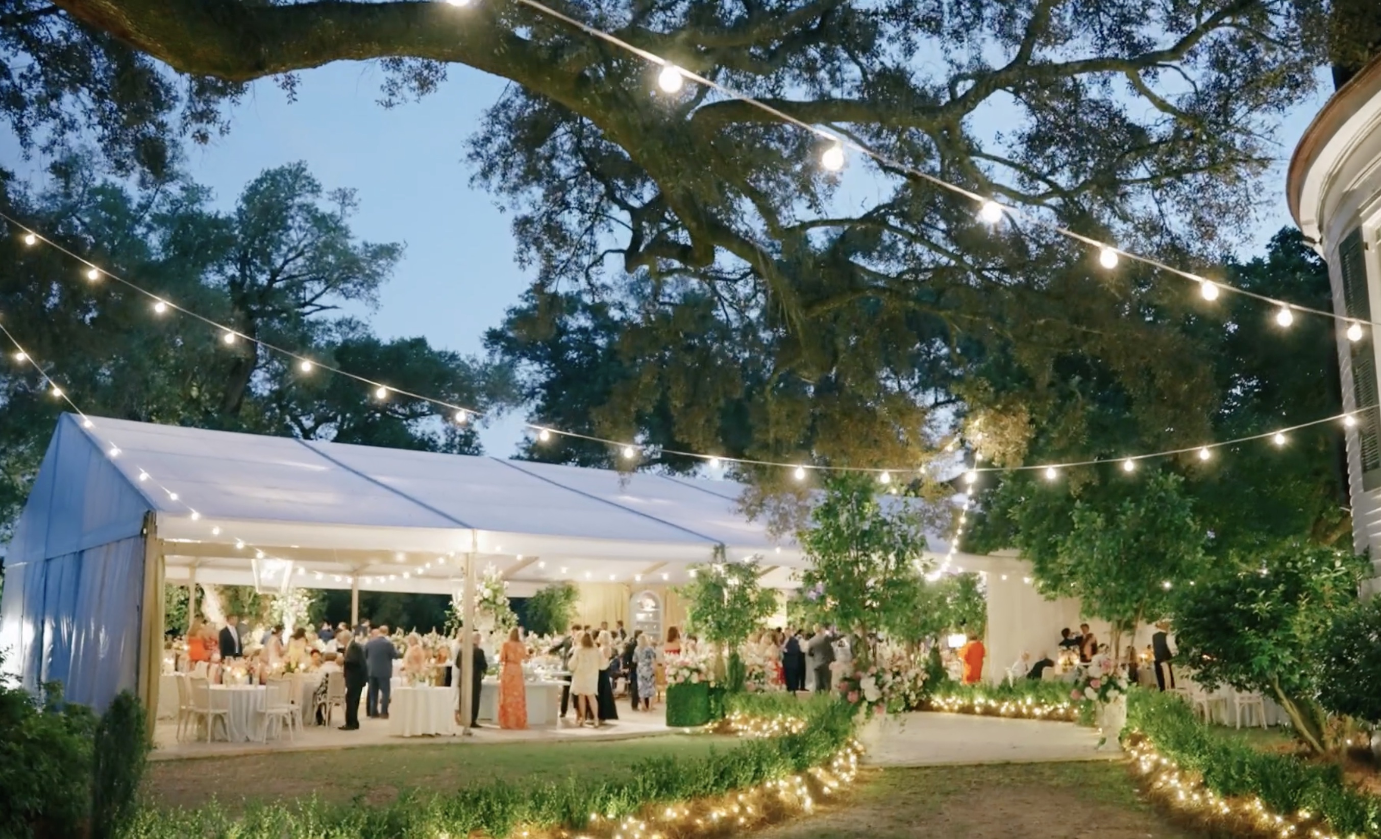 Rattan floral chandeliers with roses, hydrangea and trailing greenery under tent